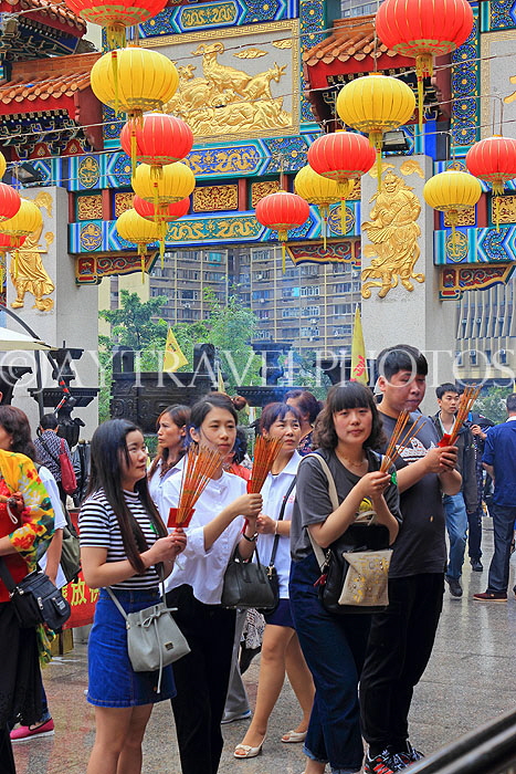 HONG KONG, Kowloon, Wong Tai Sin Temple, worshippers with incense sticks, HK1181JPL
