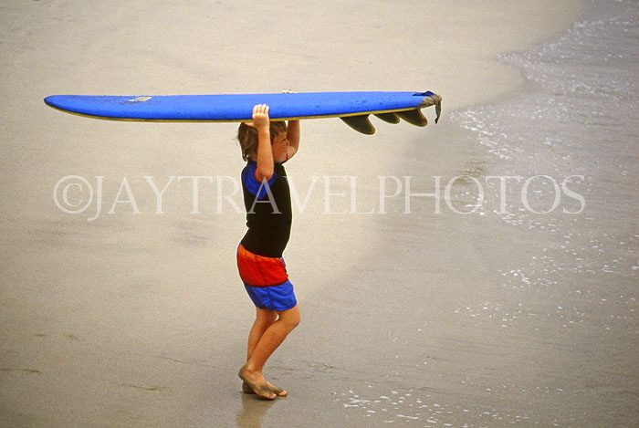 Hawaiian Islands, OAHU, Waikiki Beach, boy carrying sufboard, HAW227JPL