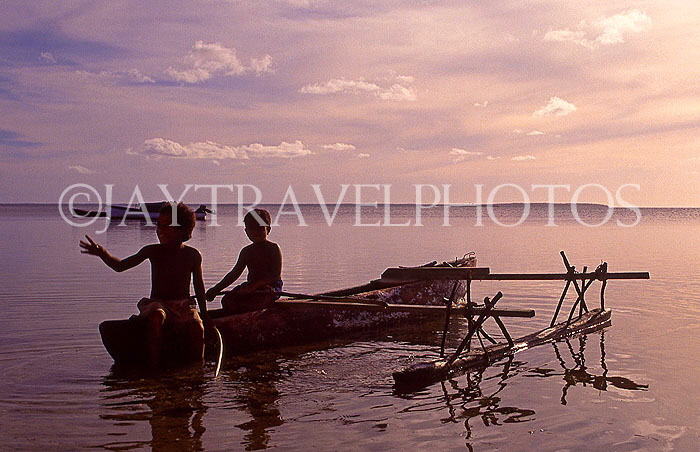 TONGA, Atata Island, two Tongan children fishing from small catamaran, dusk, TON189JPL